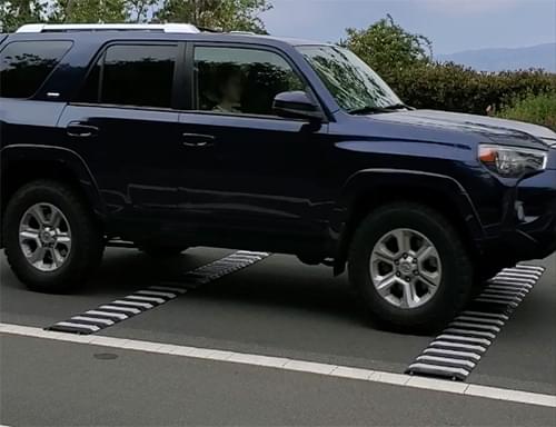 An SUV driving over a Set of TrafFix Alert High Speed rumble strips