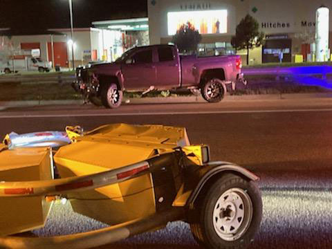A large damaged pick-up truck (background) on the side of the road after crashing into a Scorpion Towable Attenuator (foreground).