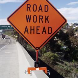 12" TrafFix Barrier Buster Clamp with Little Buster Springs, Mast, and Rigid Brackets (#29012-LBRB) with "Road Work Ahead" printed on a 48" Roll-Up Vinyl Sign.