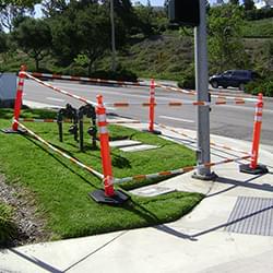 5.5' - 10.5' Orange and White Cone Bars (#150610A-CBOW) with 4x Grabber-Tube II's cordoning off a work zone.