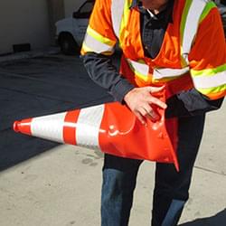 A worker taking a crushed Enviro-Cone construction cone and reshaping it back into working condition